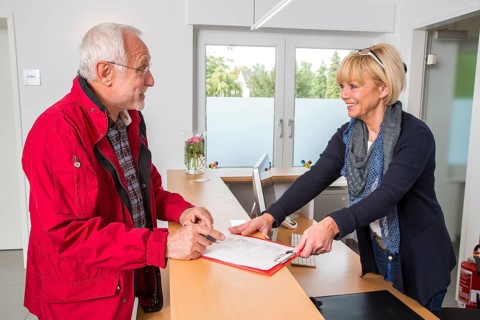 Patient filling in a form at the reception of a dental office