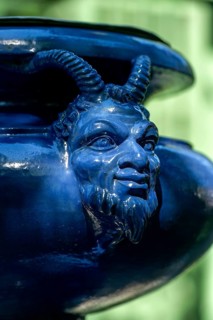 Human-animal head on an ornamental vessel made of glazed ceramic