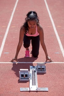 Sporty young woman getting ready on running track