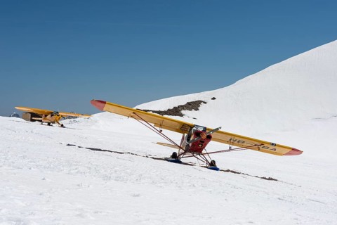 Yellow light aircrafts parking on a snowy slope on Moenchsjoch