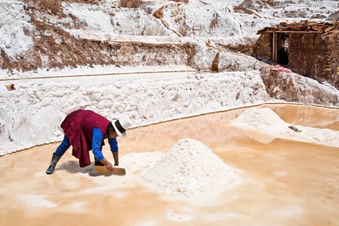 Locals piling up salt with a wooden board