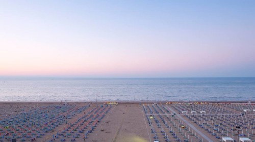 View of a beach with sunshades and sun beds