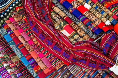 Hand-woven fabrics with the traditional patterns of the Quechua Indians are displayed for sale
