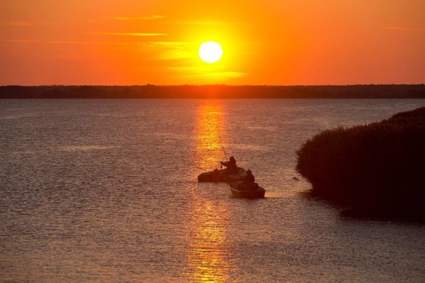 Anglers with boats at sunset on the Bodstedter Bodden lagoon