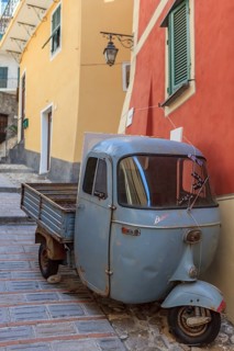 Typical Italian three-wheeled light commercial vehicle parked in an alley