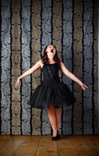 Girl wearing a black ballet dress screaming