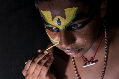 A Katakali artist is applying the make-up of the character Arjun for the Santhana Gopalam play during a temple festival