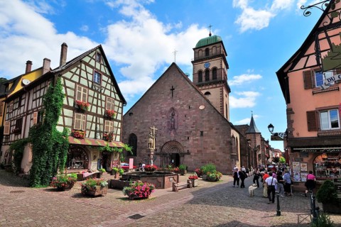 Half-timbered house and fountain in front of the Church of Sainte-Croix on the Rue du General de Gaulle