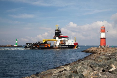 Coast Guard vessel passing two lighthouses at the harbor entrance