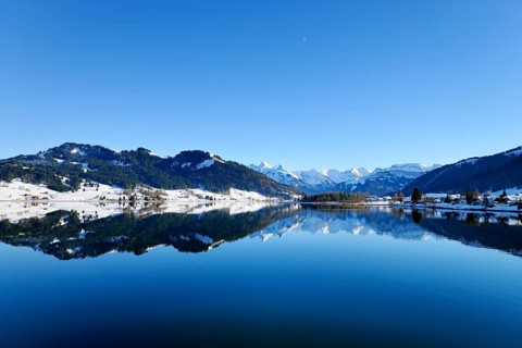 Snow-capped mountains reflected in the Sihl reservoir