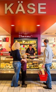 Family shopping at the cheese counter in the supermarket