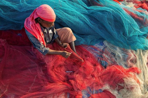 Fisherman repairing fishing nets