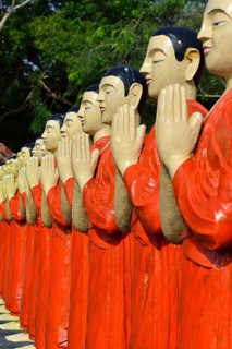 Figures of Buddhist monks in front of a monastery
