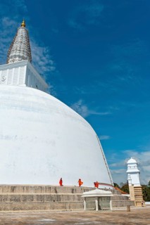 Monks at a large white stupa
