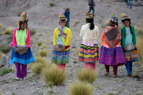 Young women carrying heavy stones to secure the shores of an artificial lake for irrigation