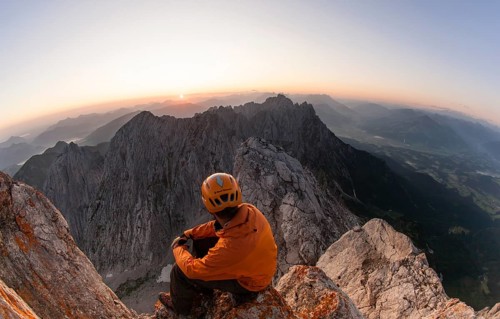 Climber sitting on the top of Ellmauer Halt at sunrise