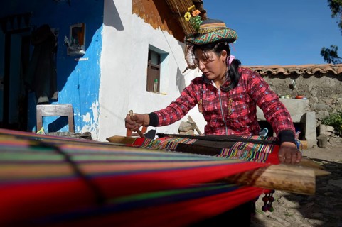 Young woman weaving traditional cloth at the loom