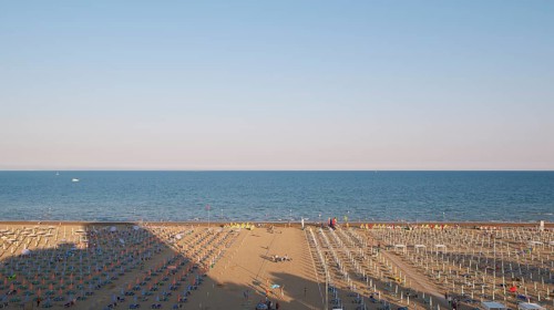 View of a beach with sunshades and sun beds in the late afternoon