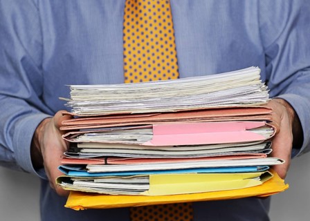 Businessman carrying a stack of paperwork