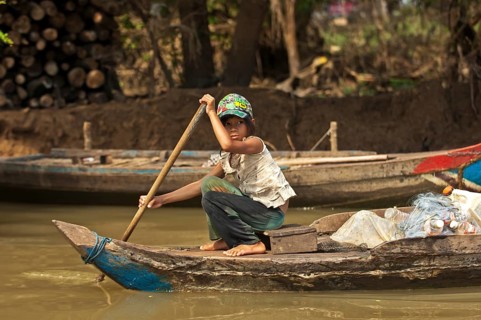 Girl paddling a traditional boat on the Sangker river in Battambang