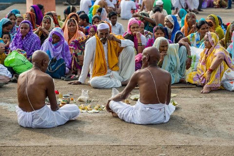 Two men and a pandit or priest are performing Dashkriya or Asthi Visarjan