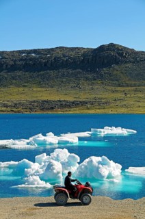 Man of the Inuit people riding a quad bike