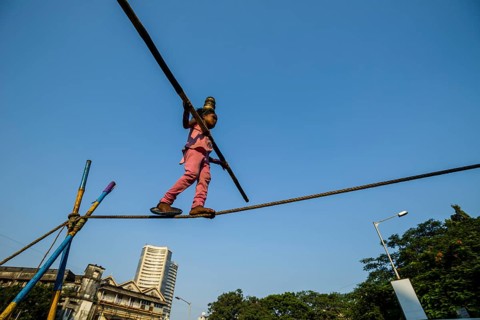 A little girl is balancing on a rope
