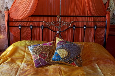 Romantic metal bed with canopy and two oriental silk cushions