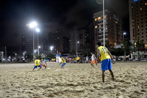 Young people playing football in the evening at the beach