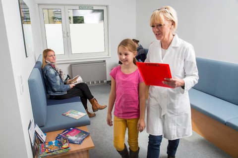 Receptionist with a patient in the waiting room of a dental office