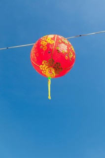 Red Chinese New Year lantern against blue sky
