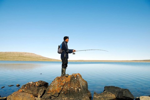 Men of the Inuit people fishing in a lake