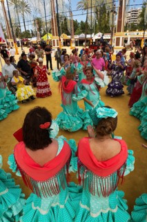 Women wearing gypsy dresses perform traditional Andalusian dances at the Feria del Caballo