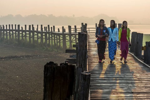 Girls with tanaka on their faces on a teak bridge