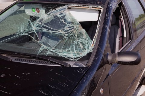 Black compact car with an accident-damaged windshield