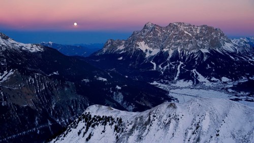 Summit of Mt Zugspitze with a full moon at dusk