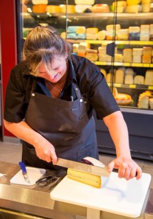 Saleswoman at the cheese counter in the supermarket