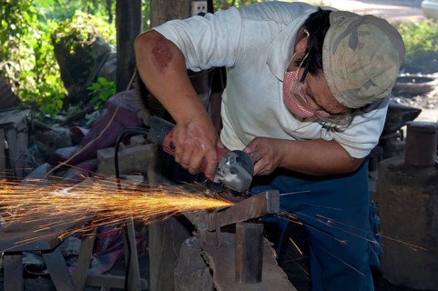 Metal worker grinding in a metalworking shop
