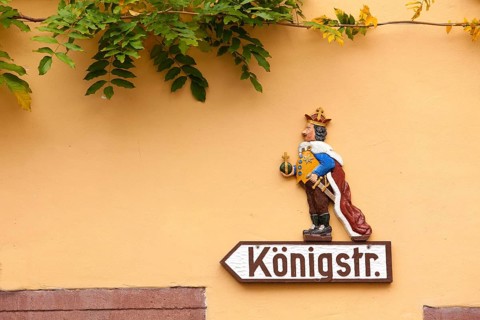 Hand-crafted street sign 'Koenigstr.' with a king