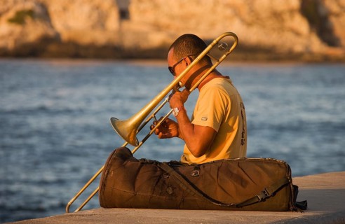 Musician playing the trombone at the Malecon esplanade