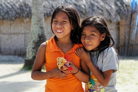 Two Kuna Indian girls holding a small soft toy