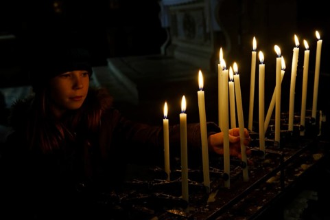 Girl lighting a votive candle