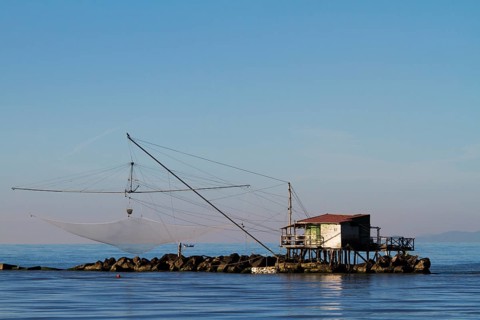 Fisherman's house with a net over the sea in Marina di Pisa