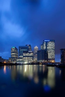 Skyline of the financial district Canary Wharf with the Blackwall Basin at the front at dusk