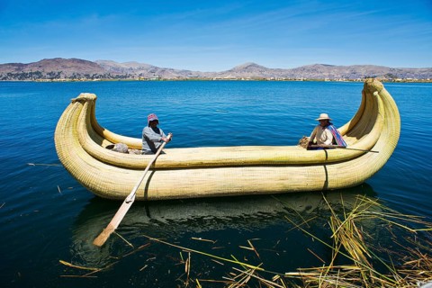 Two local in a traditional rowing boat of Totora reed on Lake Titicaca