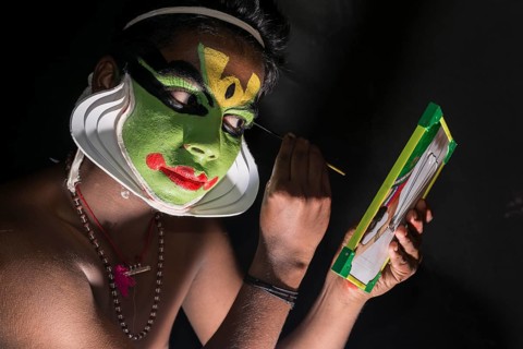 A Katakali artist is applying the make-up of the character Arjun for the Santhana Gopalam play during a temple festival