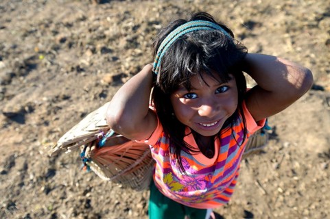 Girl carrying a traditional basket on her back in a village of the Xavantes people