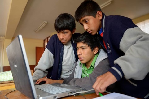 Three boys in a children's home are working together on a laptop