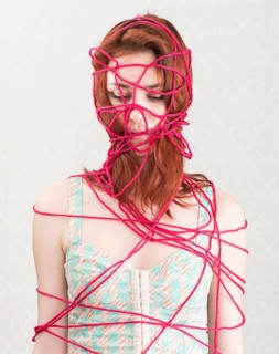 Woman constrained with pink cotton yarn