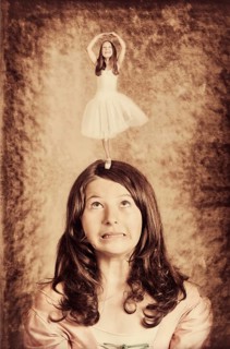 Little ballerina dancing on the head of a girl
